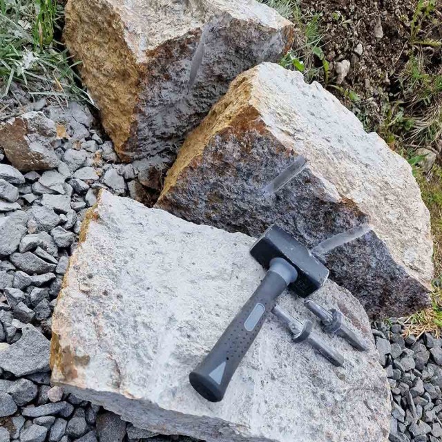 Bilde av fjellkiler med hammer meisel i bruk